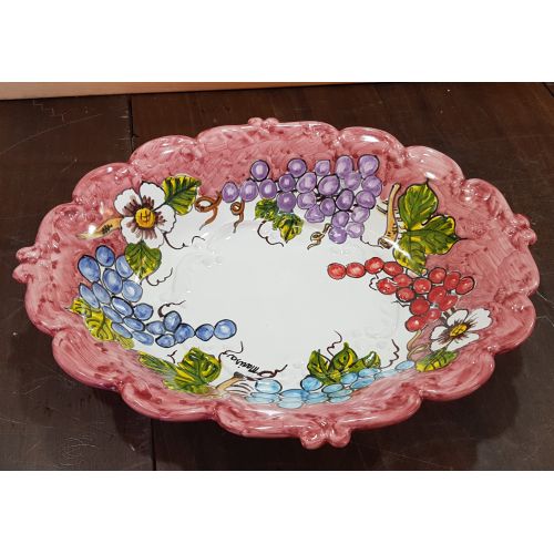 Pieza central ovalada de borde ondulado rojo viejo, decoración de frutas. Cerámica Vietri