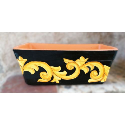 Jardinière rectangulaire. Fond noir avec baroque....