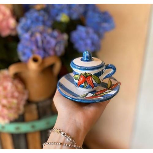 Taza de café con platillo y tapa, línea de chiles y...