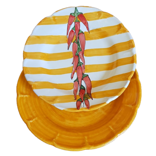 Assiettes en céramique Vietri. Lignes, rayures et piments, fond ocre brossé. Deux assiettes creuses et une assiette plate.